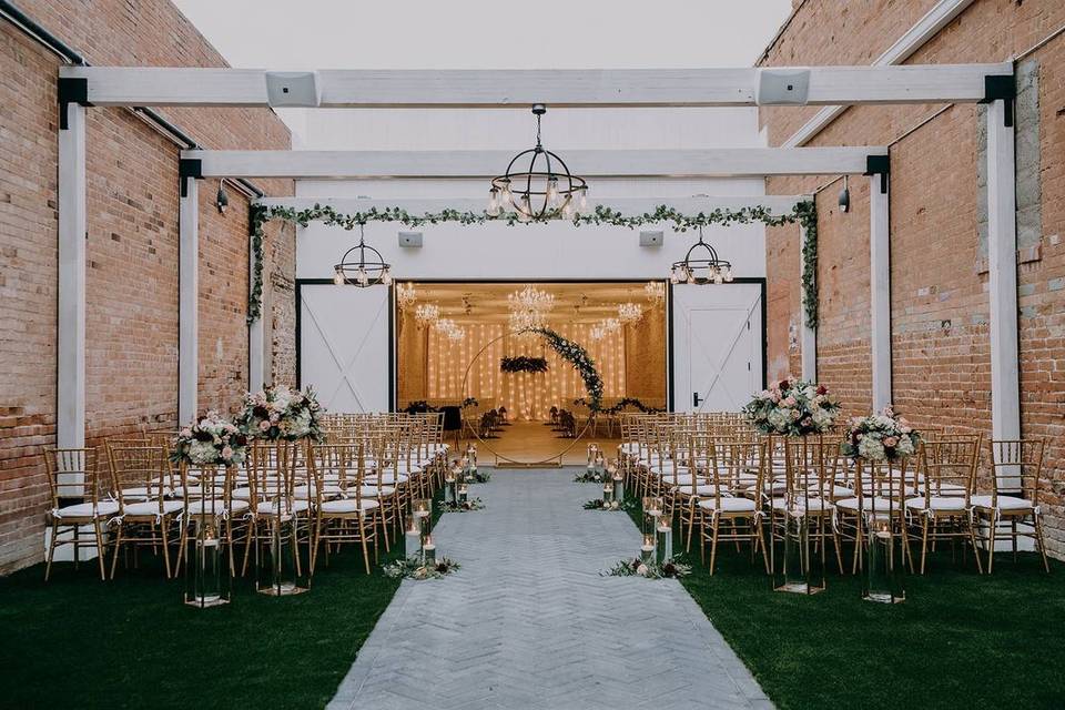 outdoor wedding ceremony with brick walls and industrial feel
