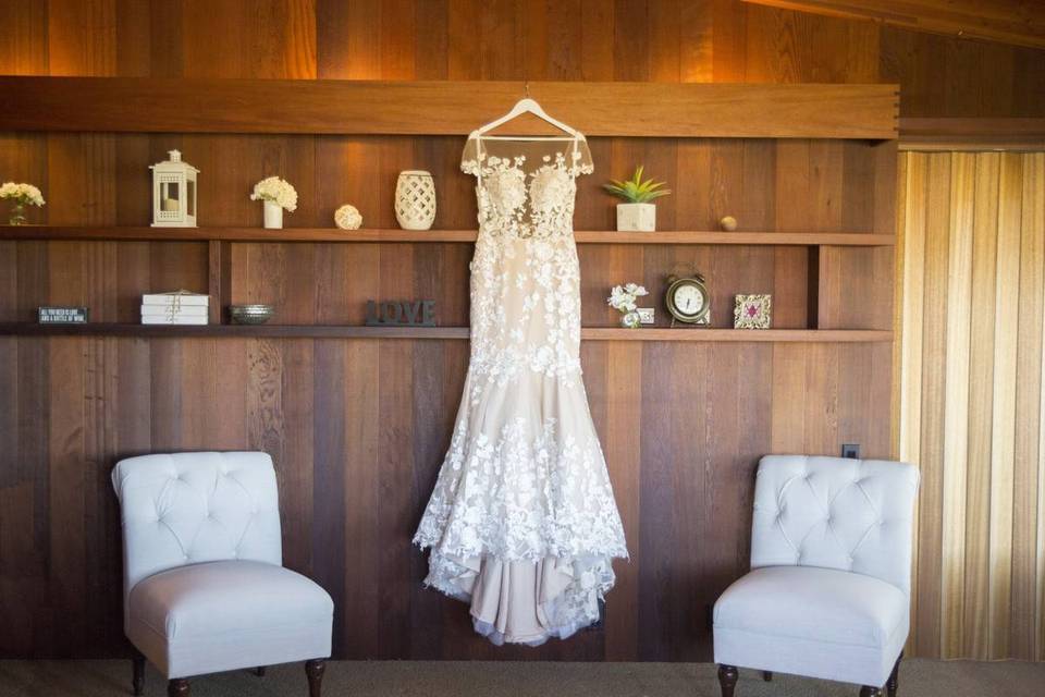 wedding dress hanging again a wooden shelving unit at home