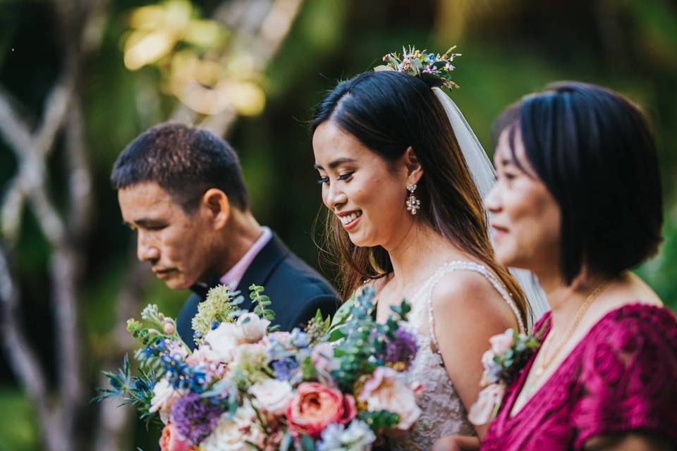 bride walks down the aisle with both of her parents
