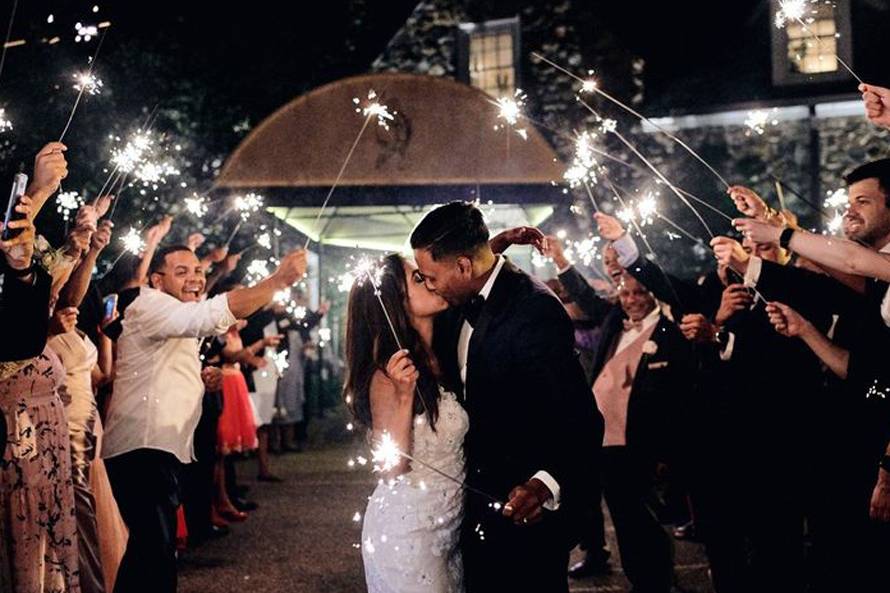 couple exiting wedding with sparklers