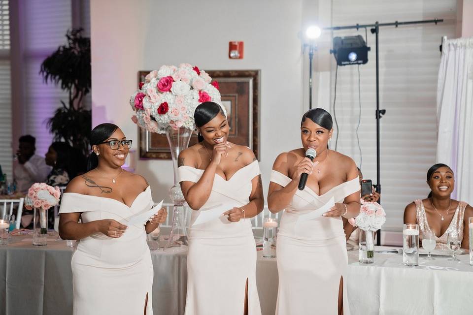 three bridesmaids stand up at the wedding reception to give a speech