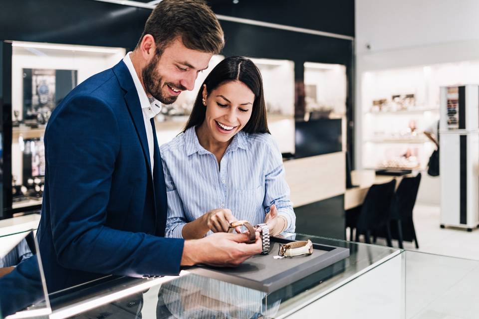 Happy couple smiling and looking at watches in a jewelry store