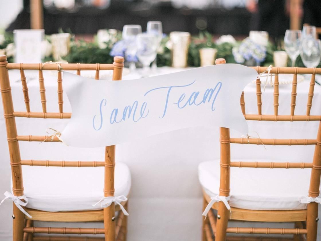 banner-style wedding chair sign with same team written in blue calligraphy