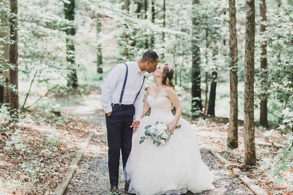 groom and bride walking in forest and kissing