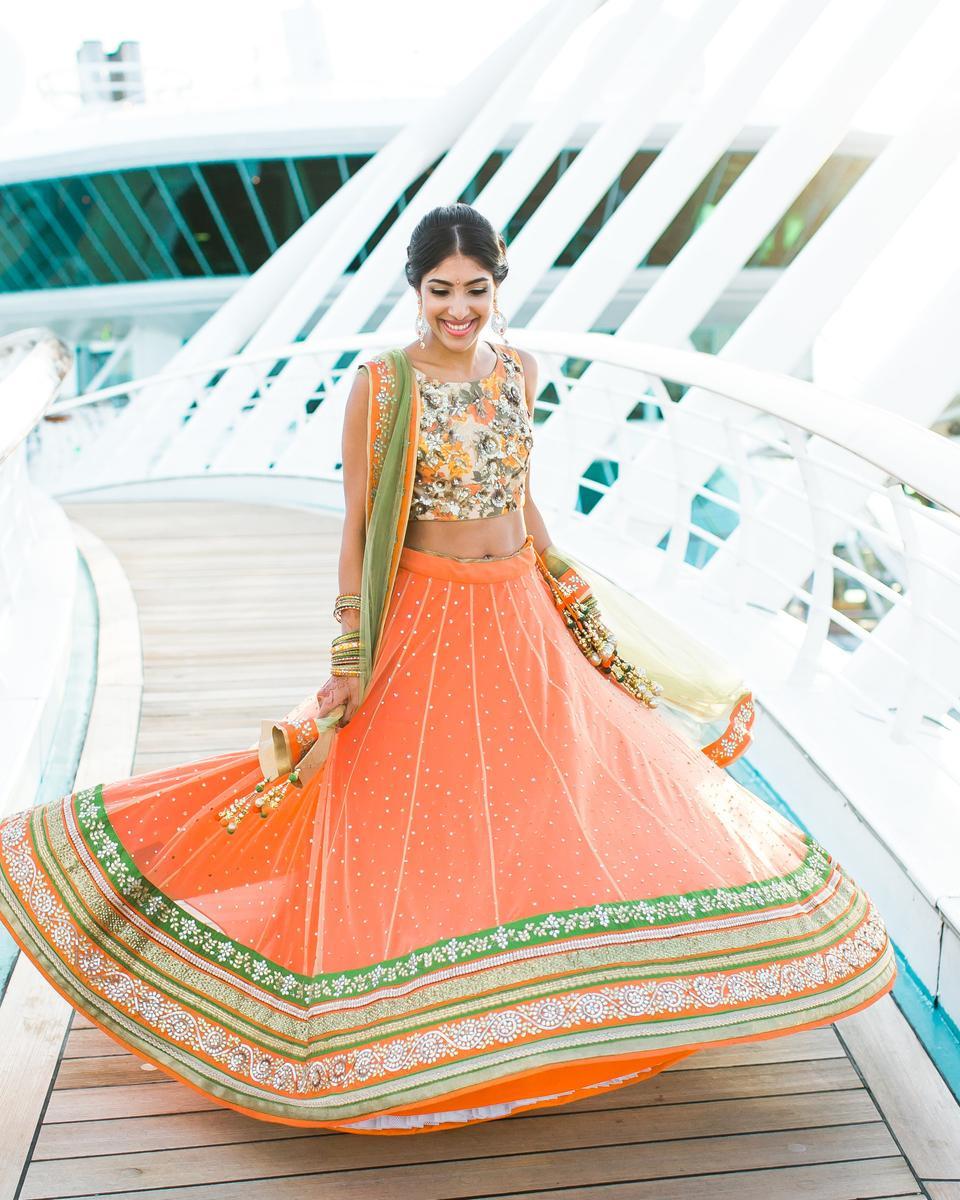 south asian bride wearing coral and green lehenga at waterfront wedding venue