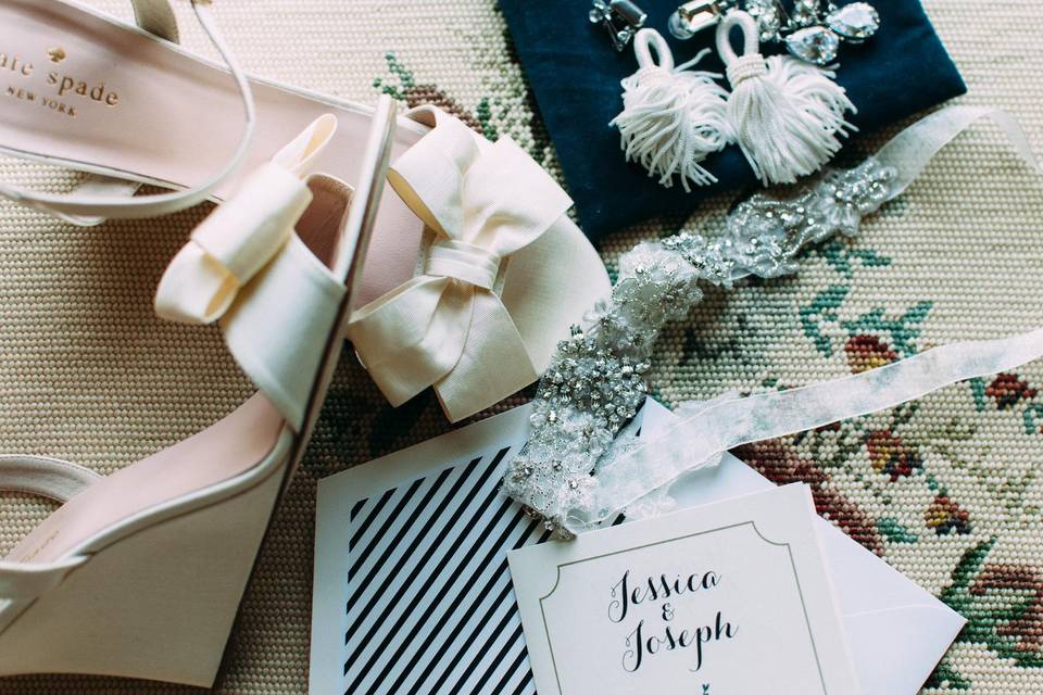 flat lay of black and white wedding paper goods, shoes and accessories