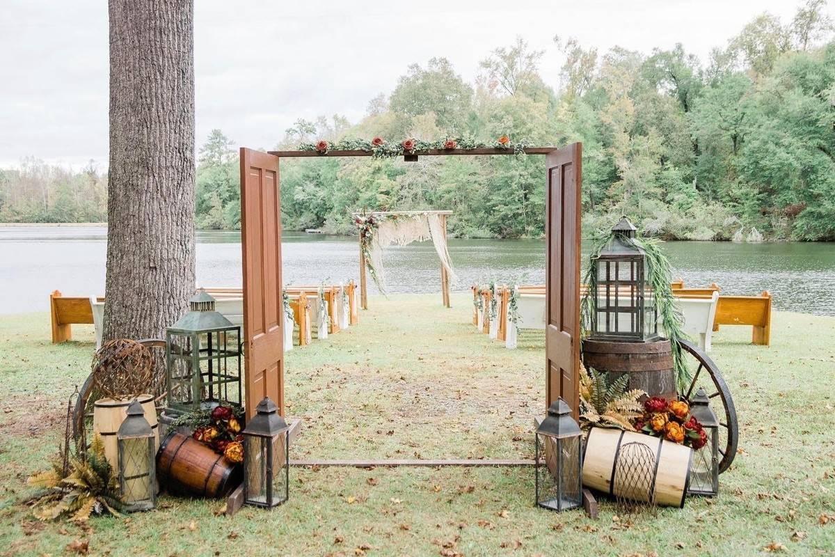 rustic outdoor wedding aisle decor barn doors at the start of the aisle with wagon wheels and barrels for display
