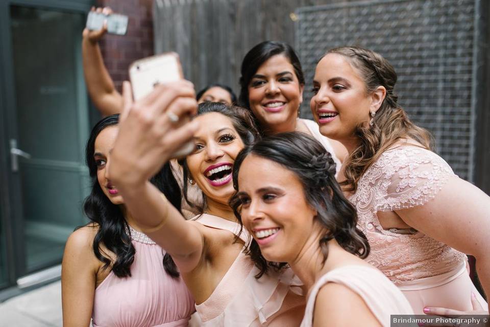 bridesmaids wearing pink dresses taking a selfie