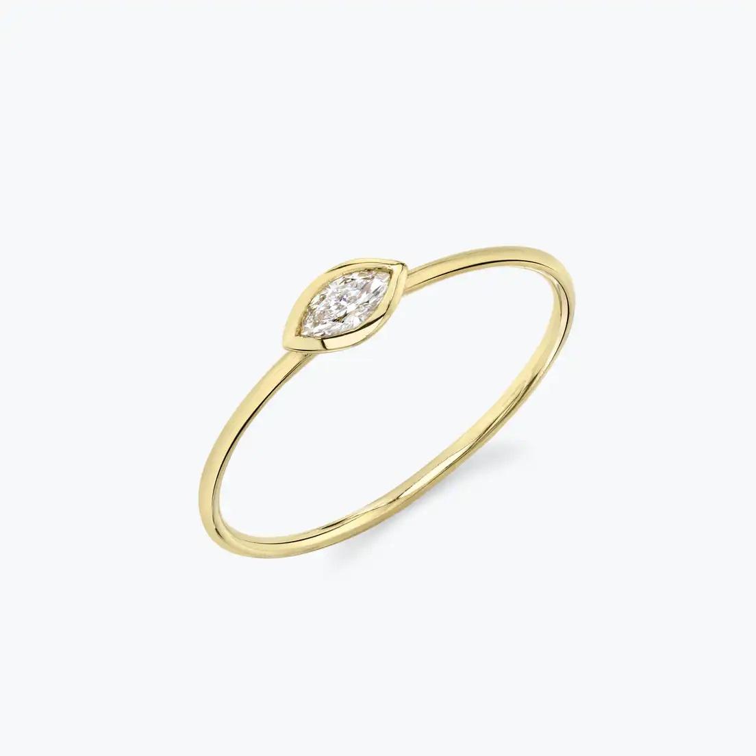 Minimalist yellow gold engagement ring with marquise-cut bezel-set diamond