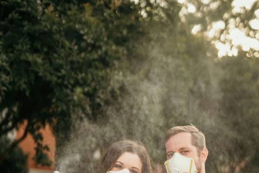 covid wedding couple holding disinfectant spray