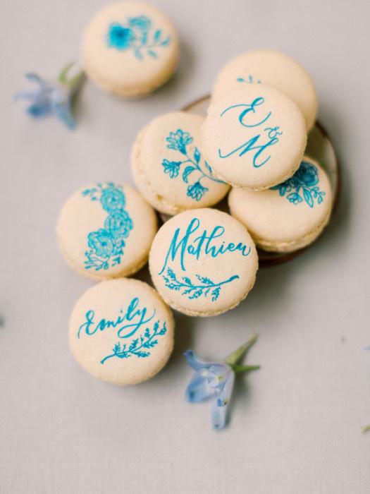 macarons decorated with names written in calligraphy using bright teal edible ink