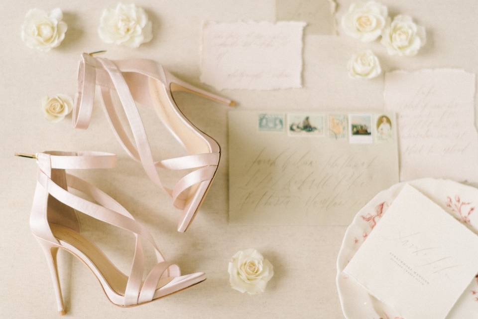 wedding shoes, invitations and fresh flowers are displayed together