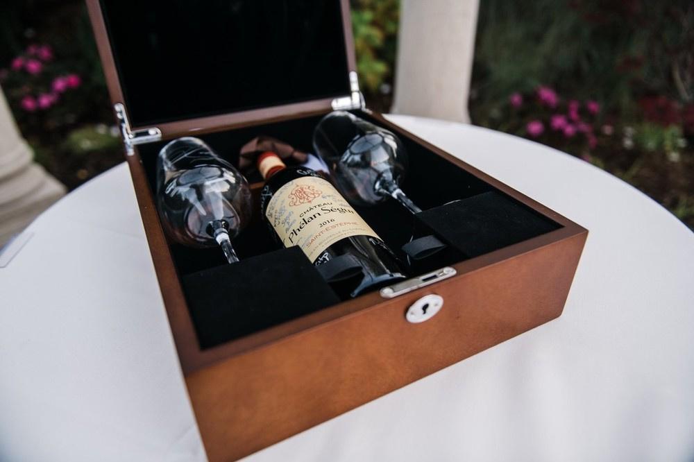 wine bottle in a wooden box with two wine glasses