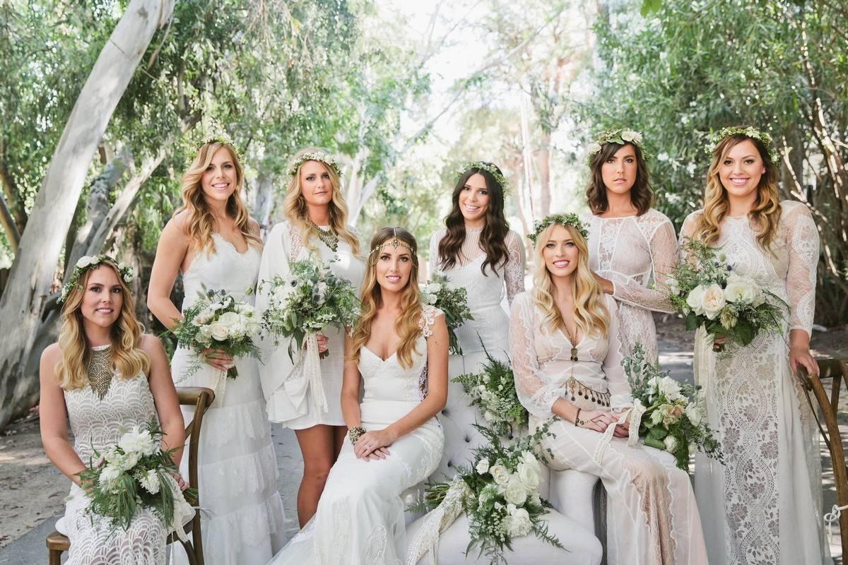 Bride posing with bridesmaids in white bridesmaid dresses