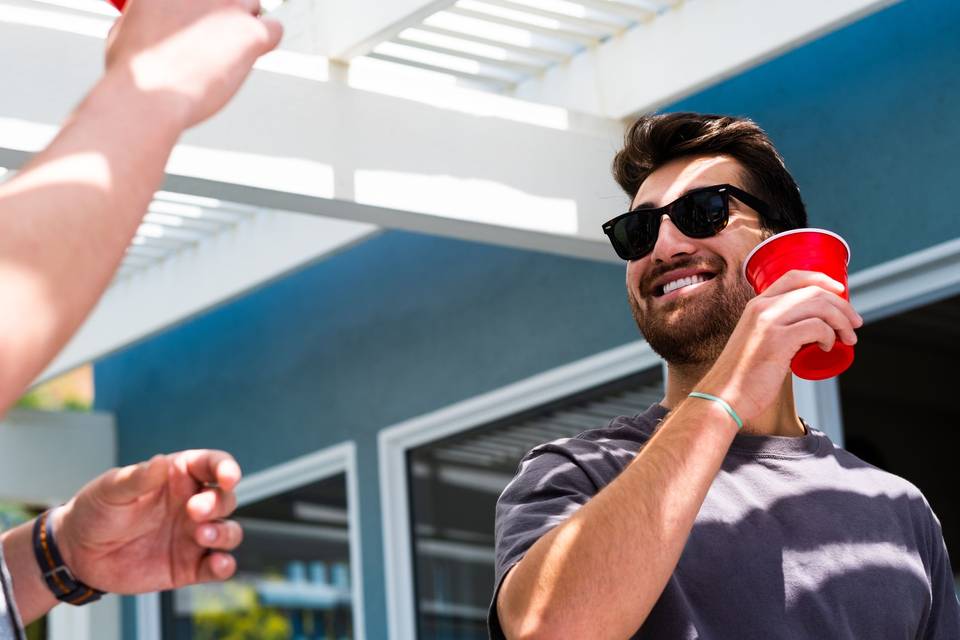 man wearing sunglasses holding a red cup