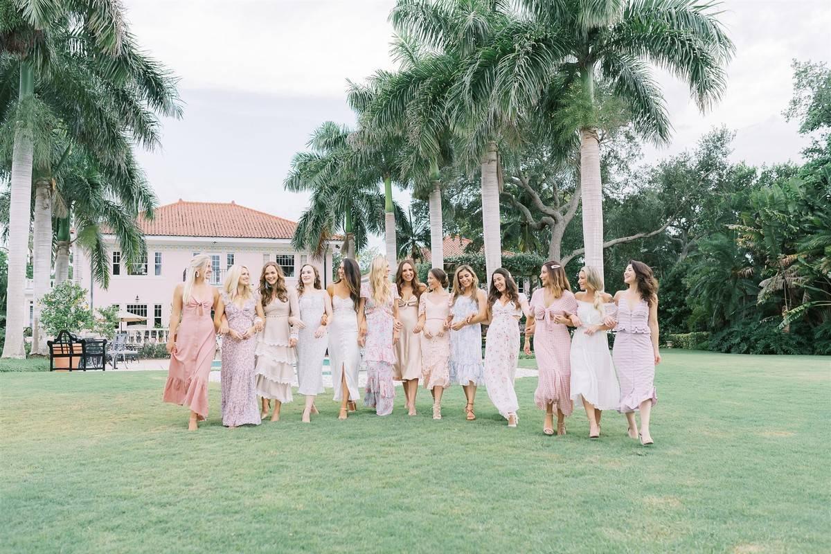 Bridesmaids and bride standing in a row with bridesmaids wearing mix and match pastel shades