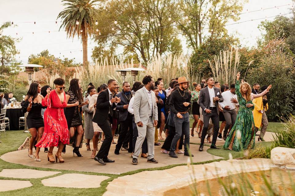 Guests gather on the dance floor at outdoor wedding venue