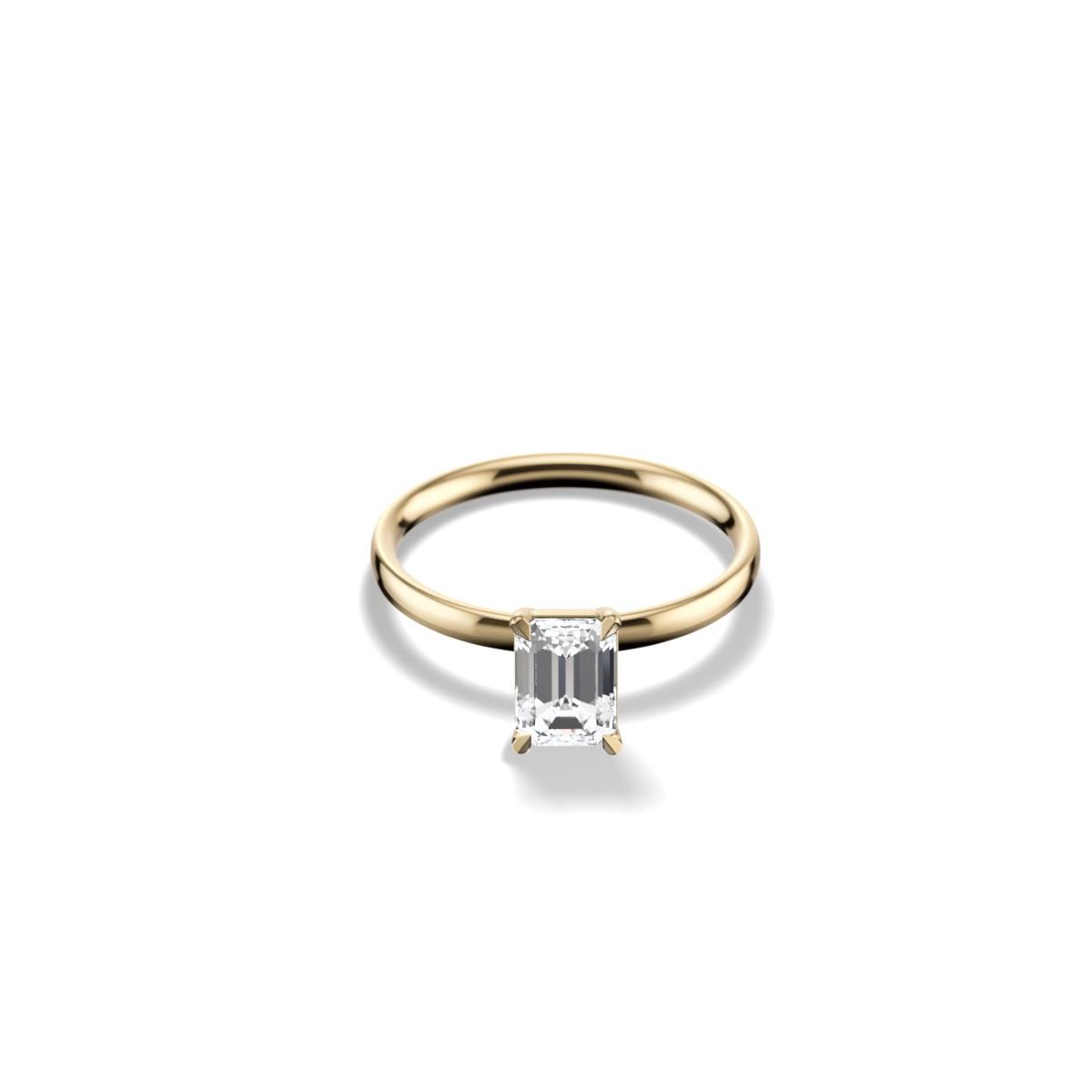 Minimalist emerald-cut engagement ring with yellow gold band