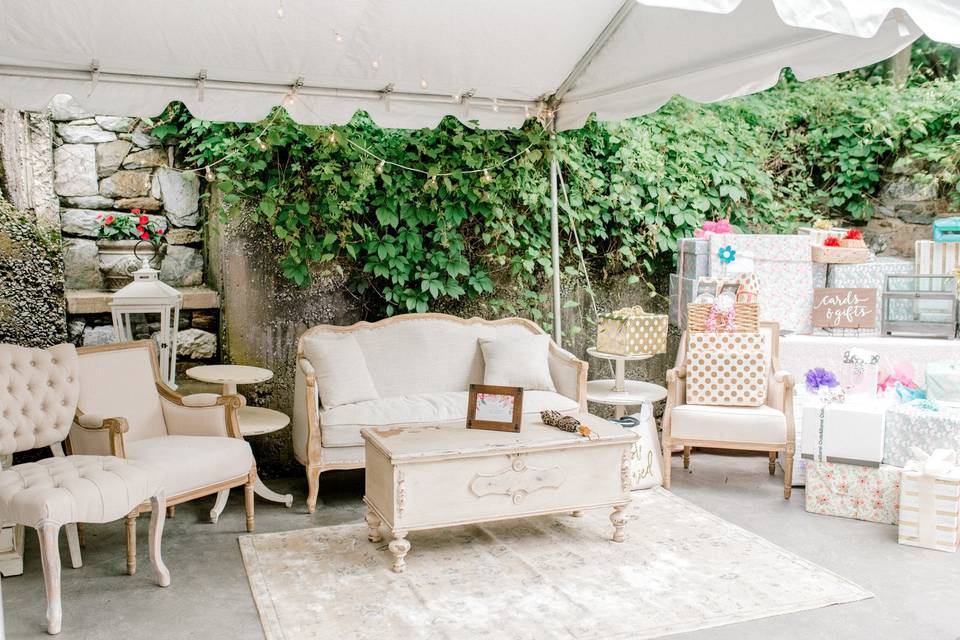 outdoor bridal shower with loveseat surrounded by gift boxes