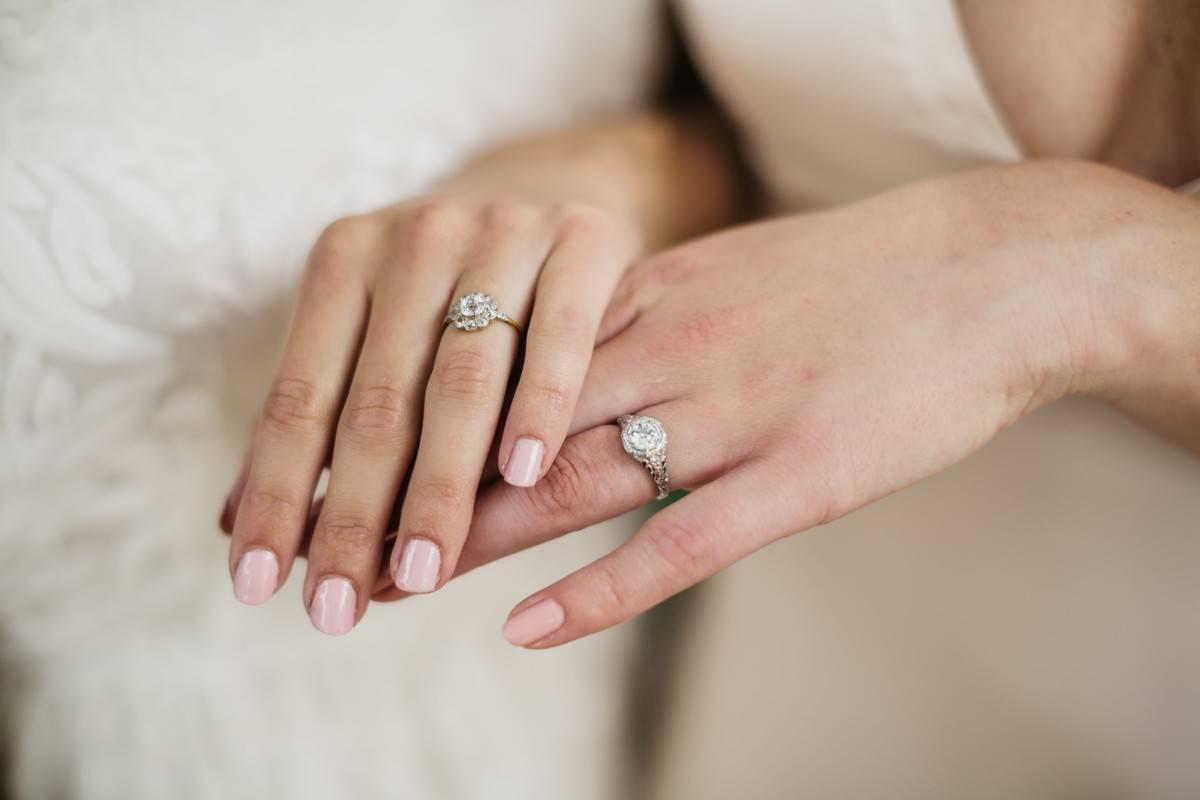 Image of Photo of the couple posing and holding each other's fingers and  showing rings during the typical Indian engagement ceremony.-HU694217-Picxy