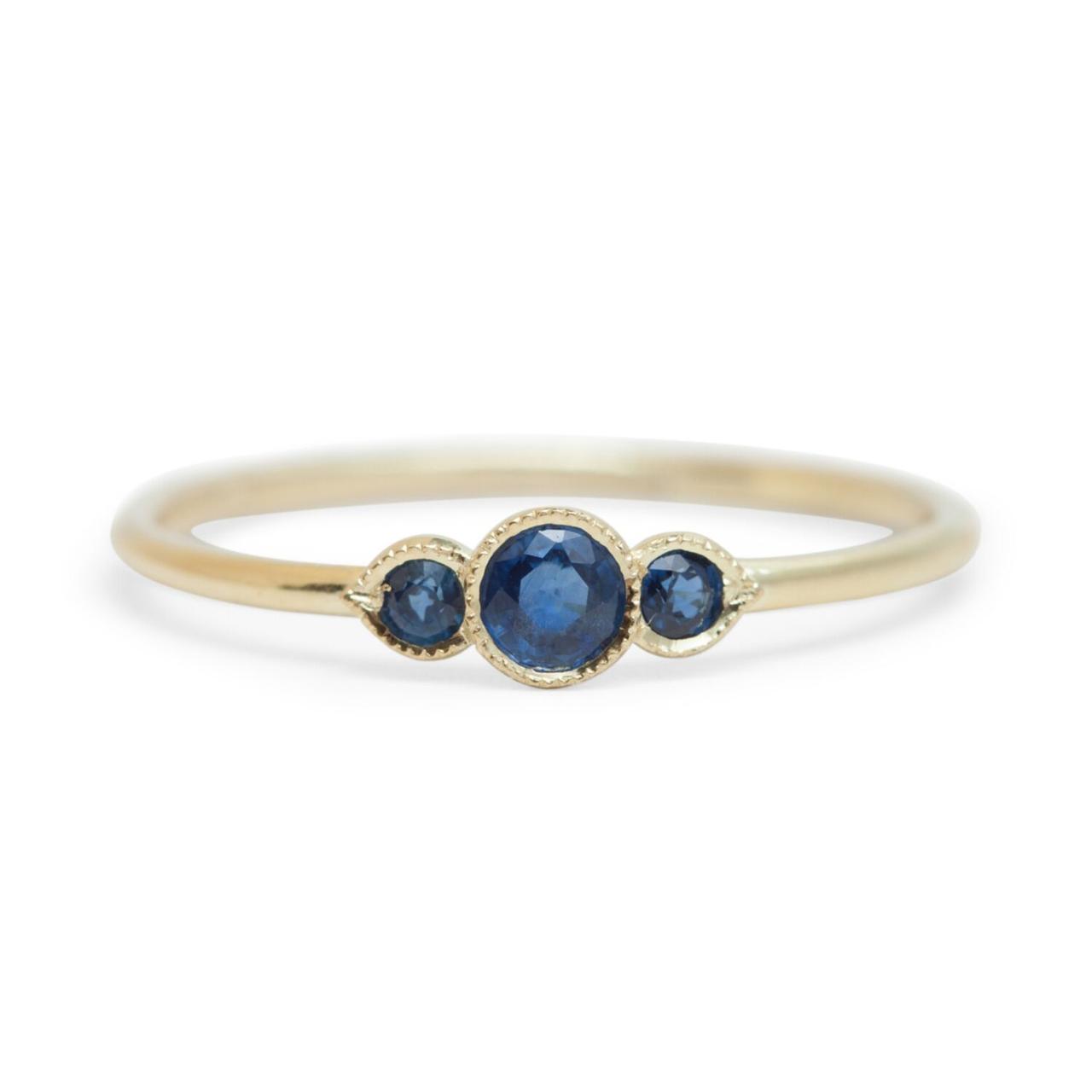 Minimalist three-stone sapphire engagement ring with yellow gold band