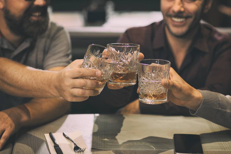 men toasting glasses of bourbon