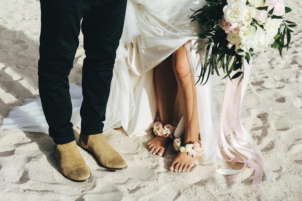 bride wearing floral anklets for hawaii beach wedding