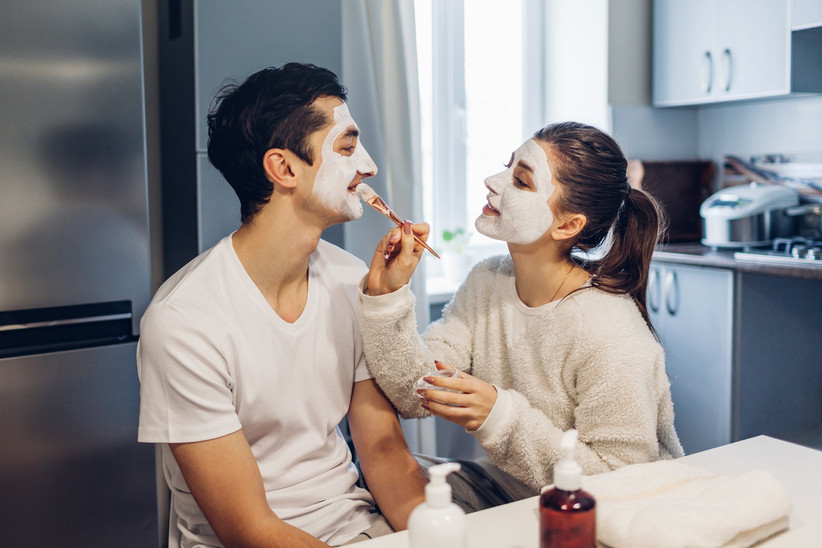Couple painting mud masks on each other's faces