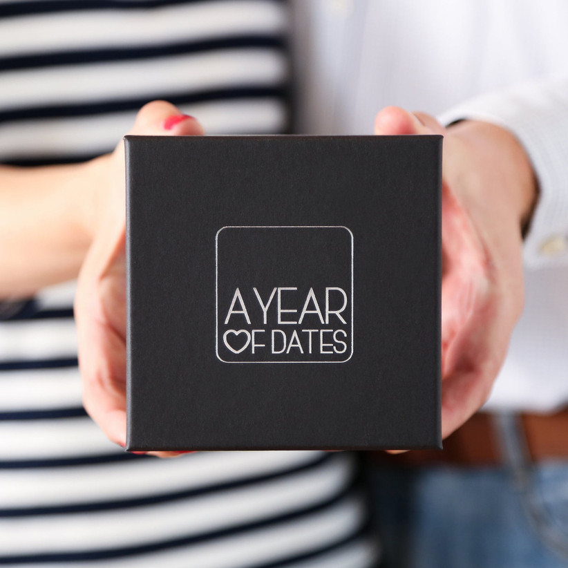 woman holding black box with year of dates printed in white lettering
