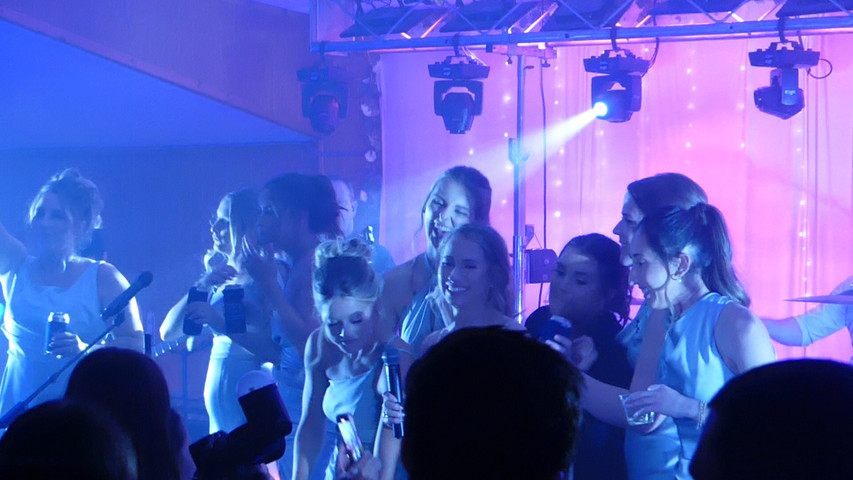 Bride + Bridesmaids + Friends singing on stage at their Wedding Celebration with ‘The Emotions'