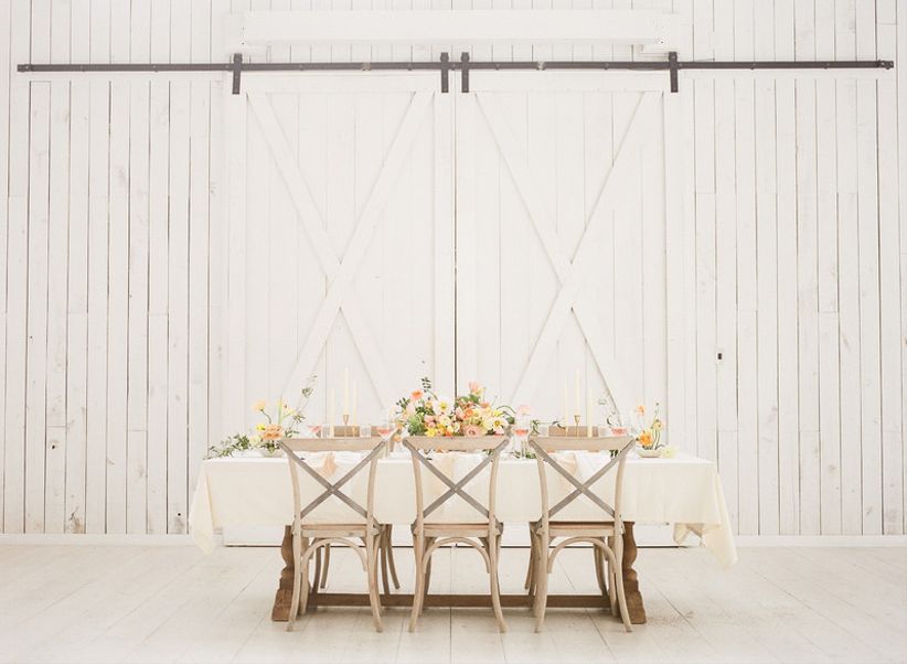 whitewashed X-back chairs at barn wedding reception