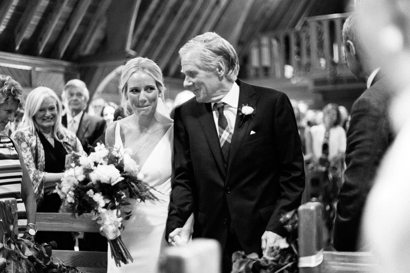 Las tendencias de la fotografía de bodas que las parejas amarán totalmente novia y padre caminando por el pasillo en blanco y negro