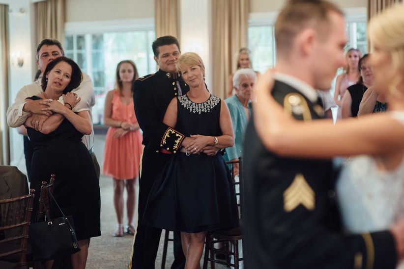 18 fotos de padres del día de la boda Los padres miran a los recién casados durante el primer baile.