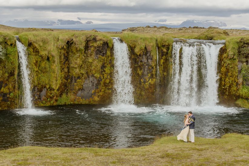 Las fotos más románticas de bodas reales Pareja posando con fondo de cascada escénica