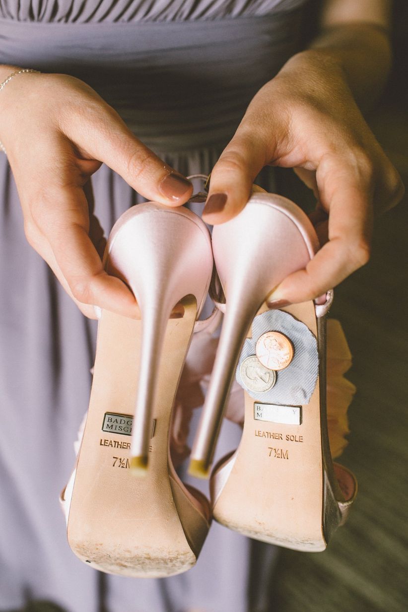 bride holding shoes with sixpence