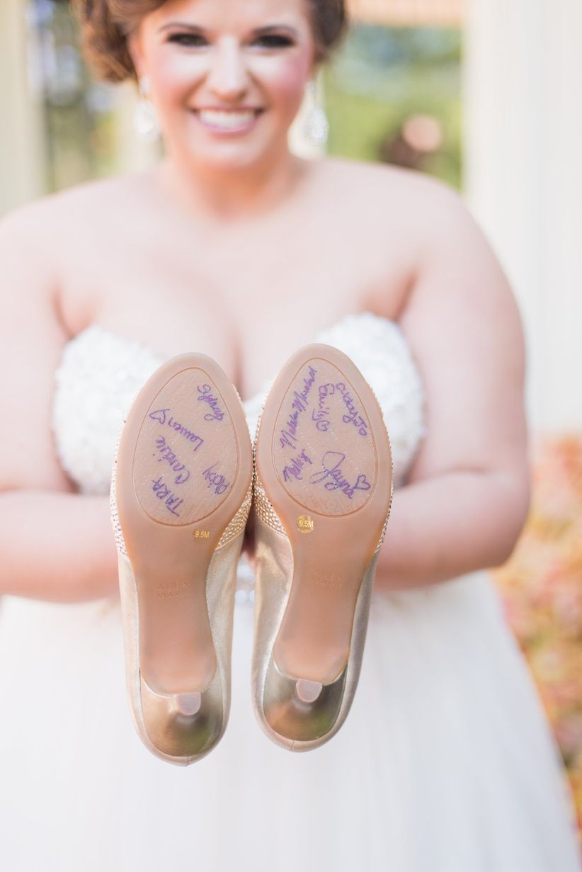 bridesmaid signing soles of brides shoes