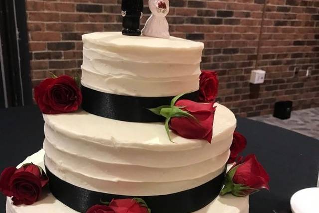 Two tier black and white fondant cake, decorated with a few bright red  roses to complete the look 🌹 💝credit to original artist/baker .…