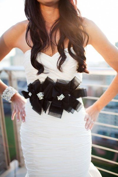 Who is wearing a black sash with their gown?