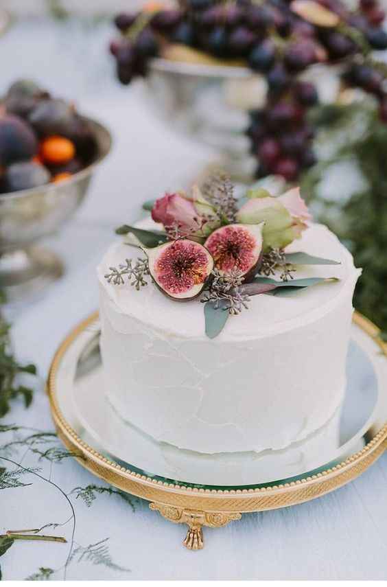 small wedding cake on stand with fruit