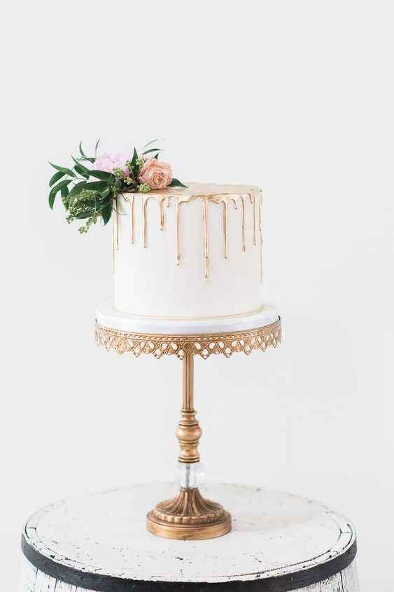 small wedding cake on tall stand with gold detail