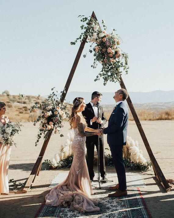 triangle wedding arch with large bundles of flowers