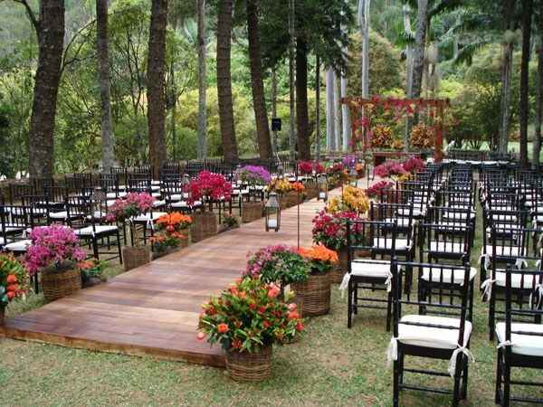 wooden barrel with colorful flowers lining ceremony aisle