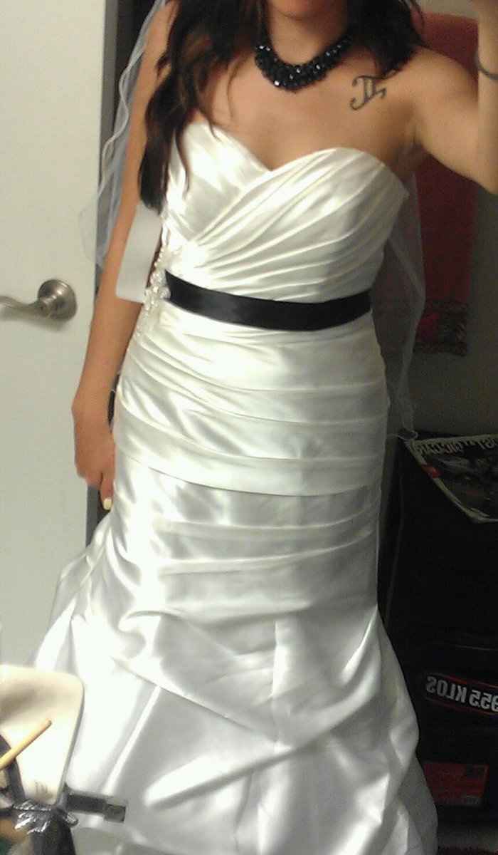 Who is wearing a black sash with their gown?