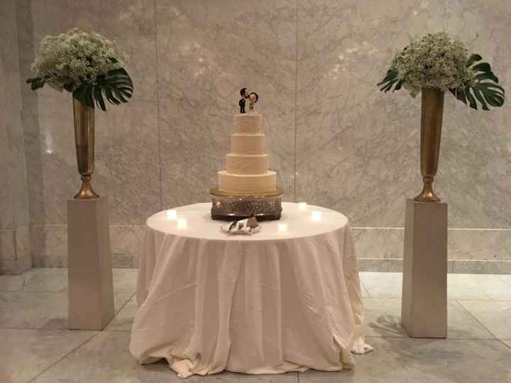 Our cake with topper and floral pieces from the ceremony space