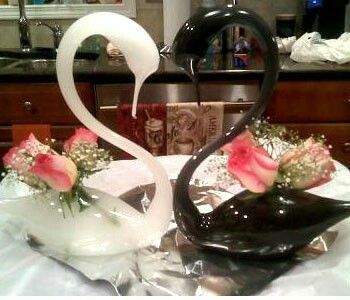 C. Both swans white with fake dark red flowes and baby's breath.