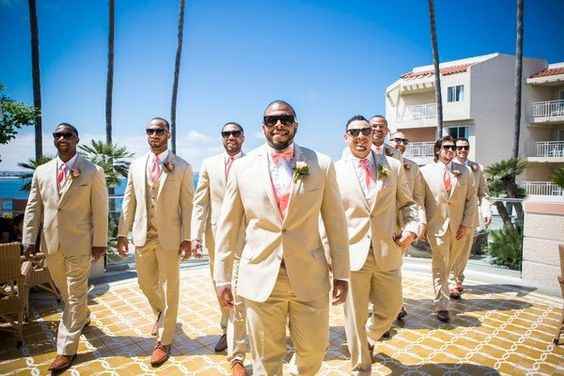 African-American groom and groomsmen wearing beige/tan suits and coral ties