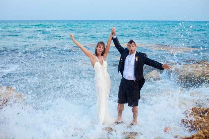 couple dressed in white wedding dress and suit trashing outfits in ocean 