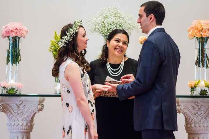 Female wedding officiant marrying couple