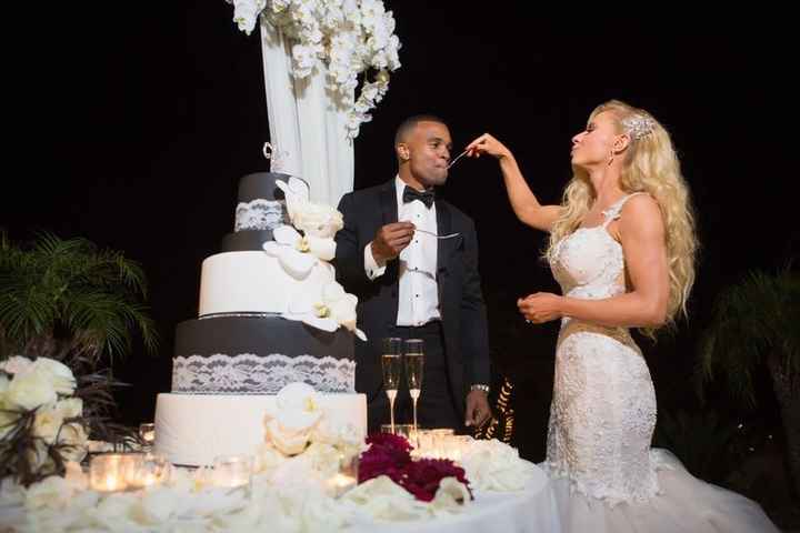 Bride and groom feeding each other wedding cake at reception