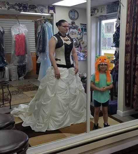 Front of the gown is being lowered to hide behind the sweetheart top of the corset.